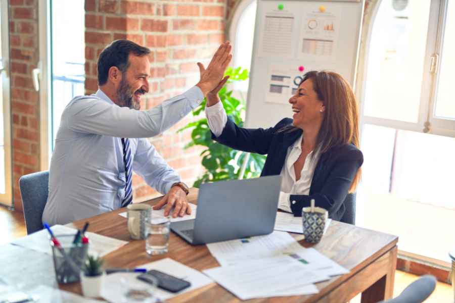 man and woman high- fiving over a table