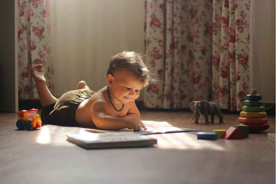 baby reading picture book on the floor