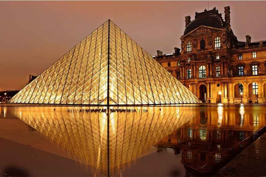 a lighted up pyramid above water