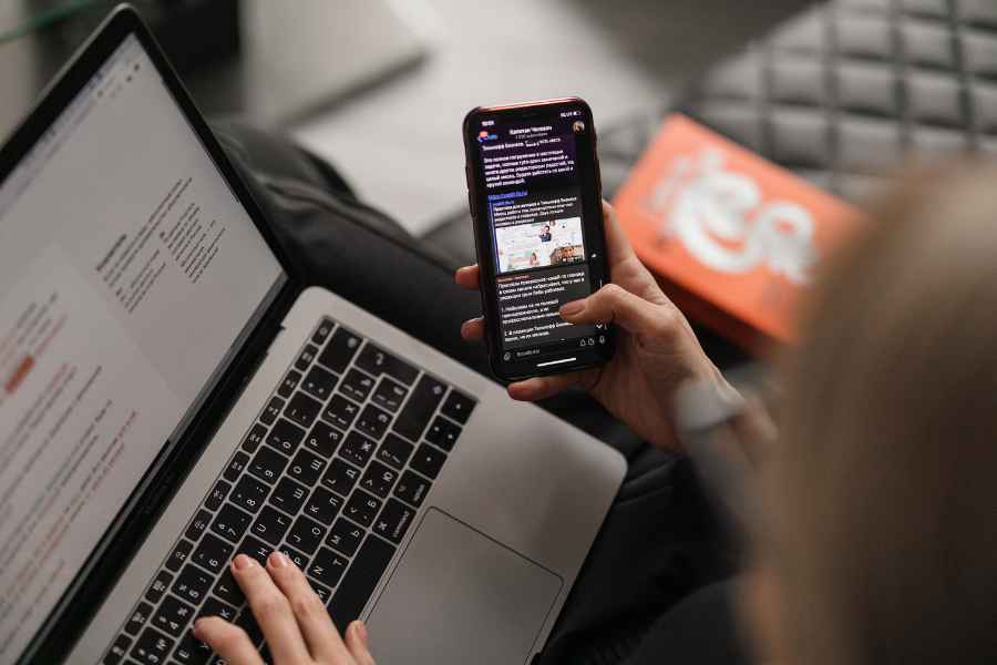 a woman uses a phone and a laptop