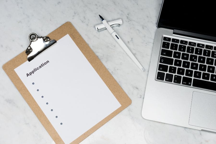 a clipboard next to a laptop