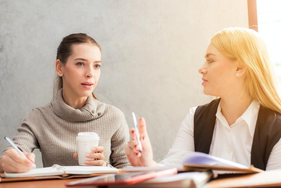 Two female coworkers having a conversation