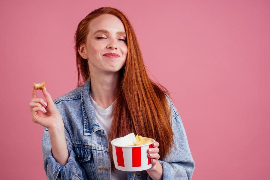 woman smiling as she eats kfc