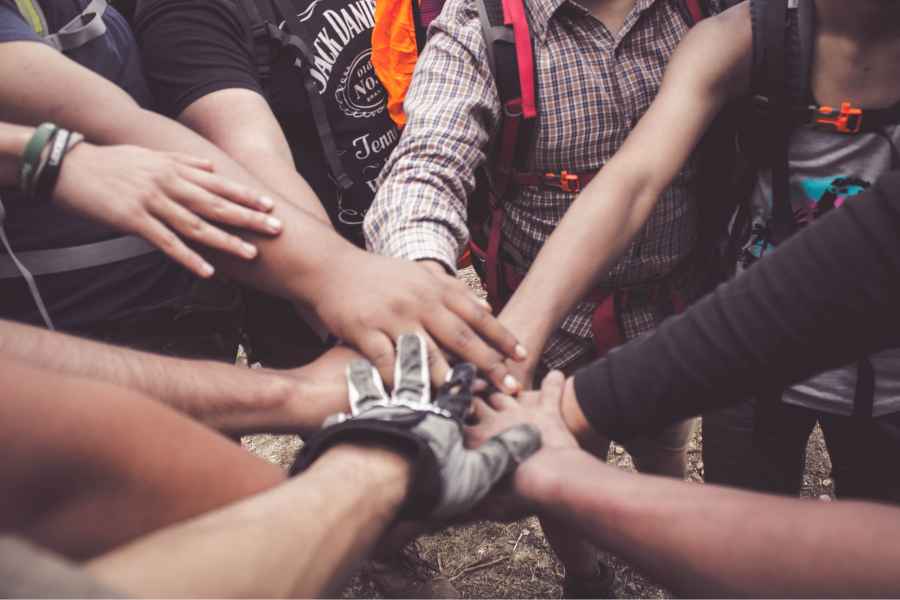 a group of people putting their hands in the center of the circle