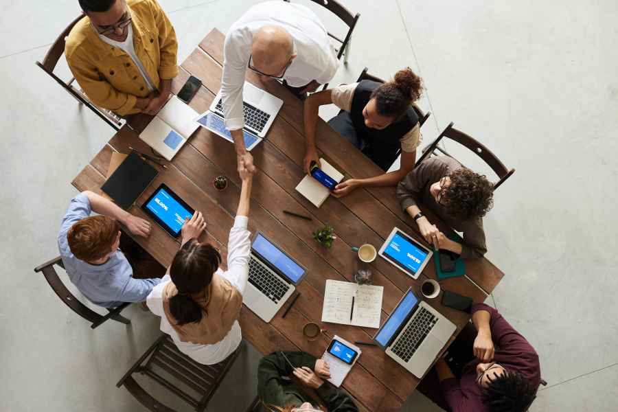 people with laptops sitting around a table