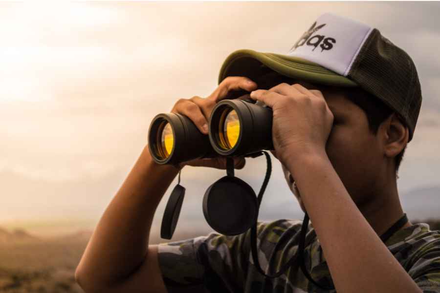 man looking through binoculars