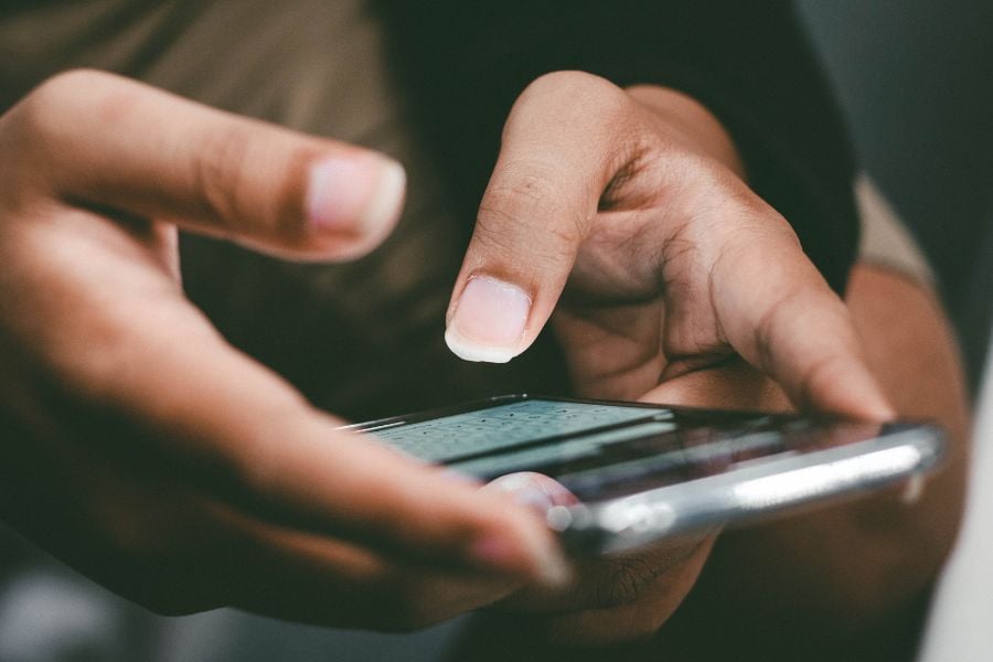 hands typing on a smartphone keyboard 